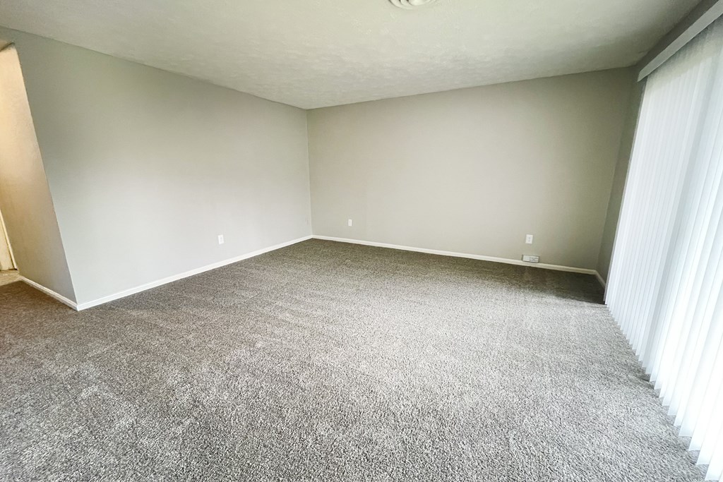A room with a carpeted floor and white walls.