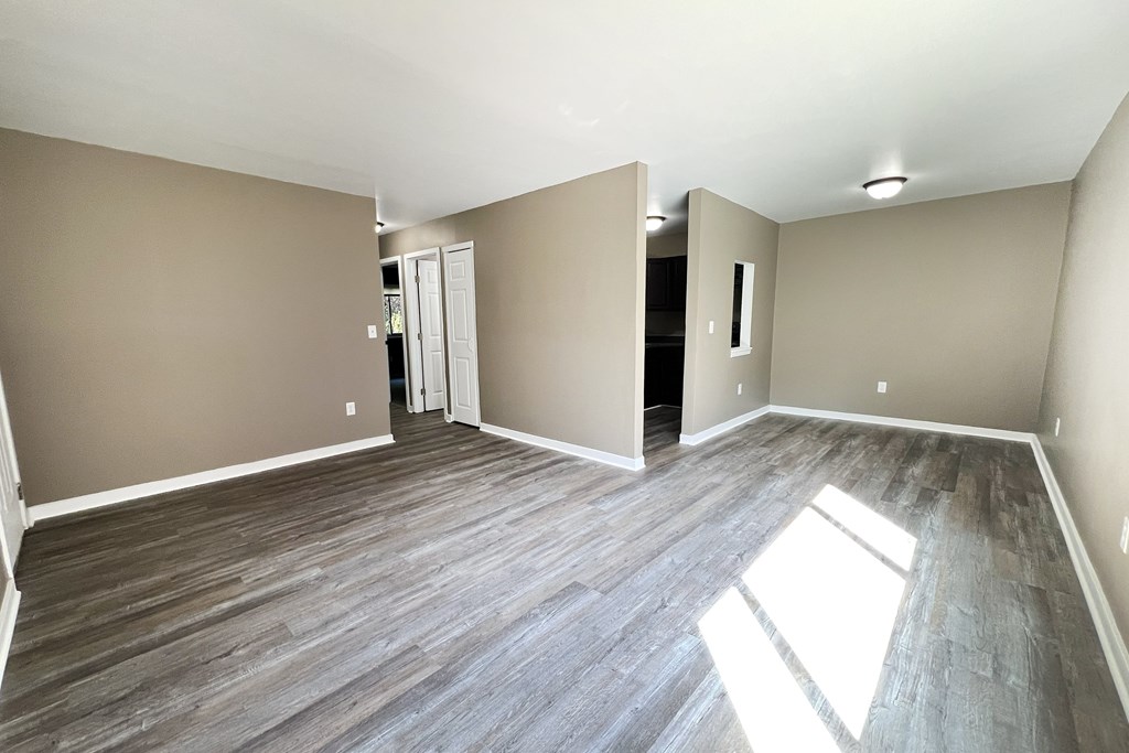 A room with wooden flooring and a white door.