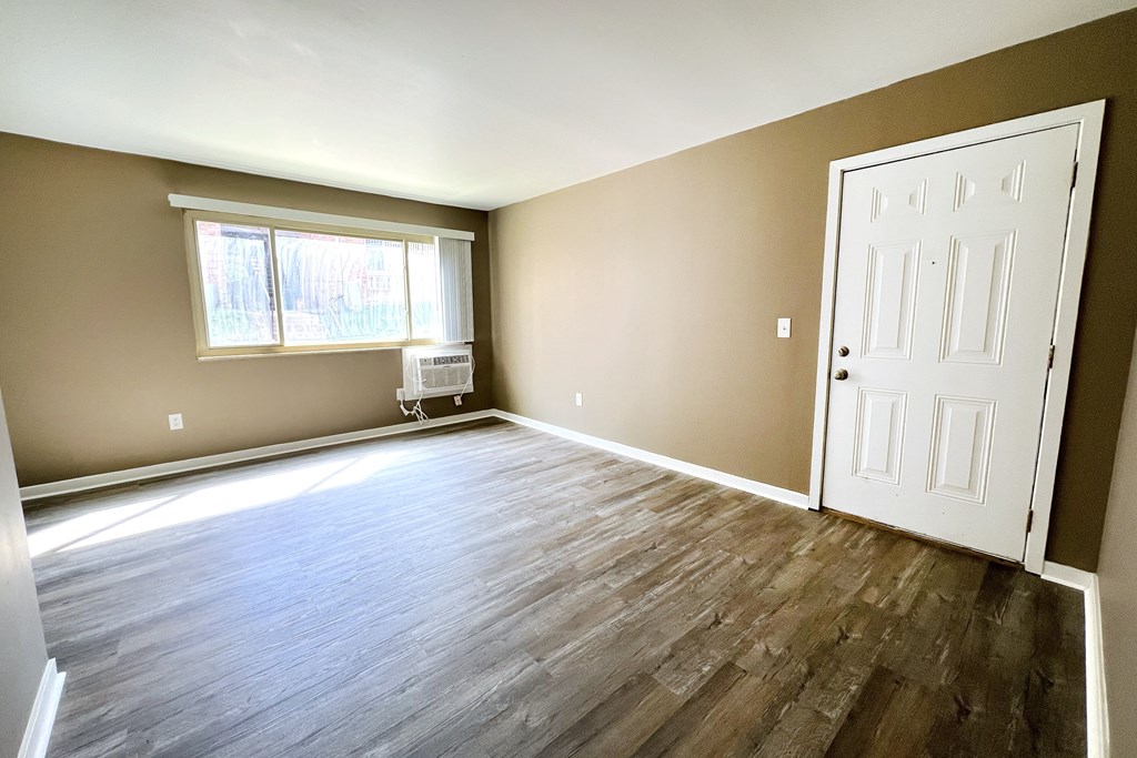 A room with a white door and a window with blinds.