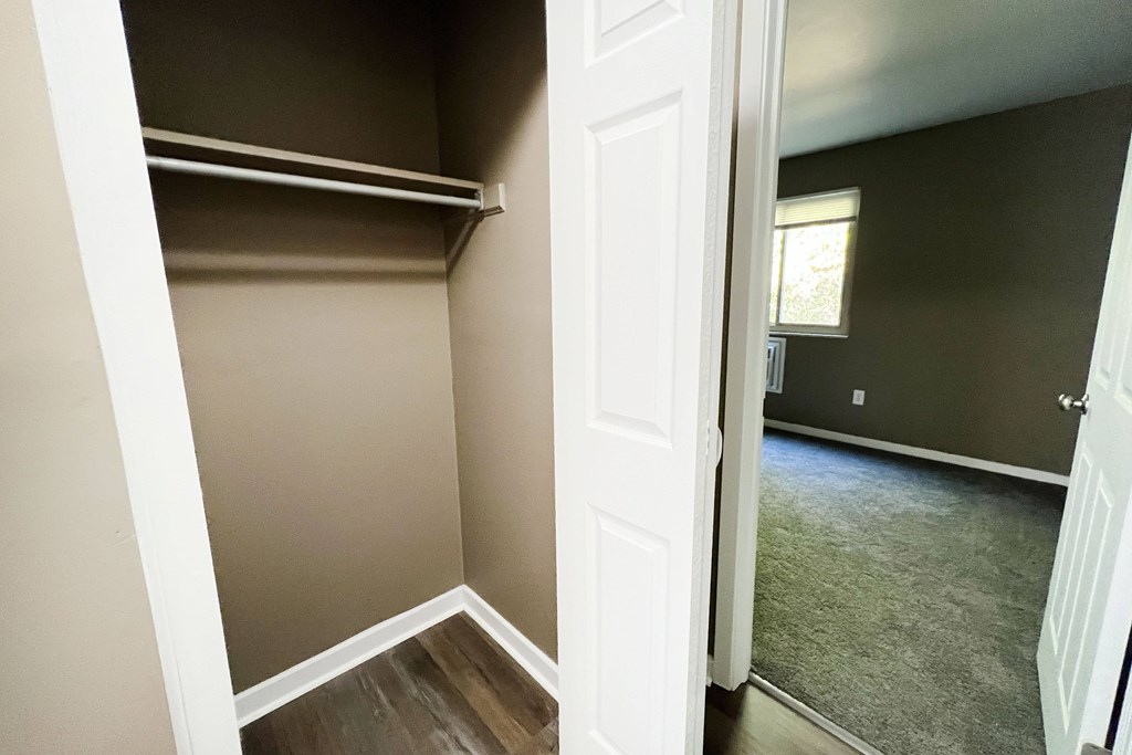 A white door is open to a room with a grey carpet.
