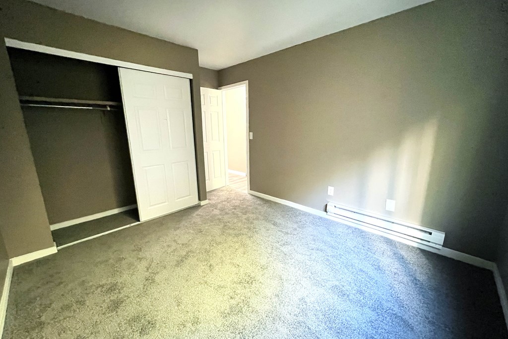 A room with a carpeted floor and a sliding door.