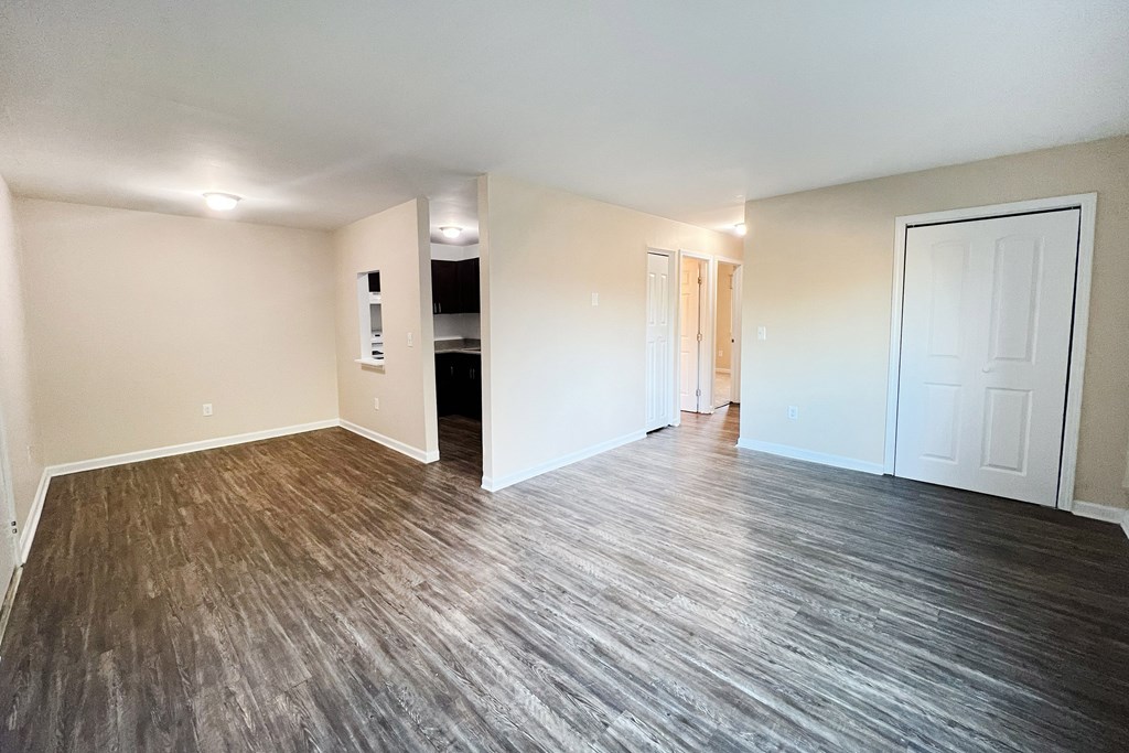 A room with wooden flooring and white walls.