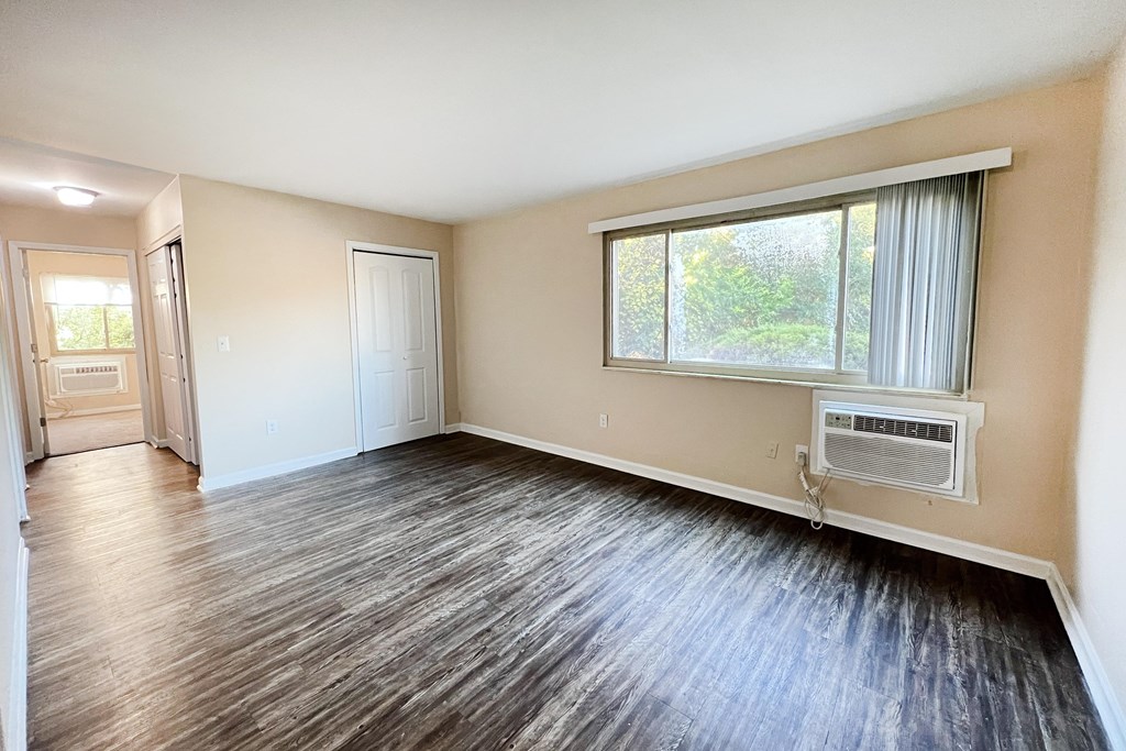 A room with a window and a wall-mounted air conditioner.