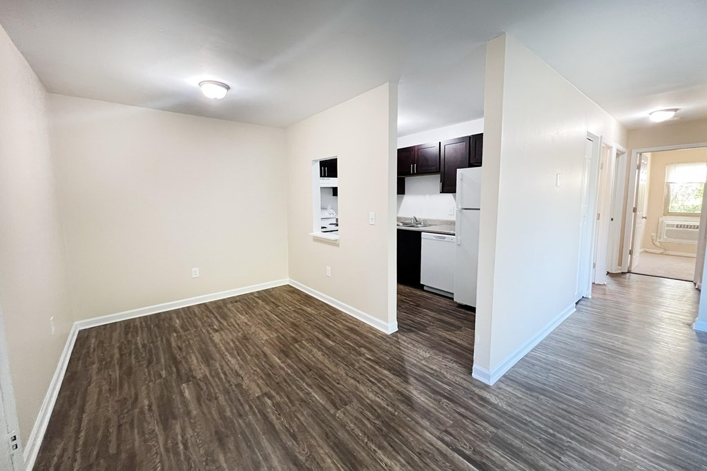 A room with wooden flooring and white walls.