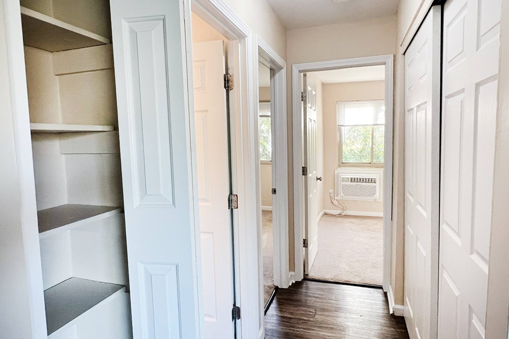 A hallway with white doors and a sign that says "Welcome".