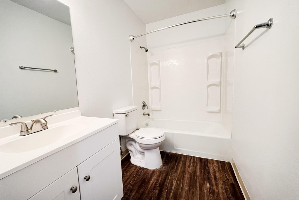 A white bathroom with a toilet, sink, and bathtub.