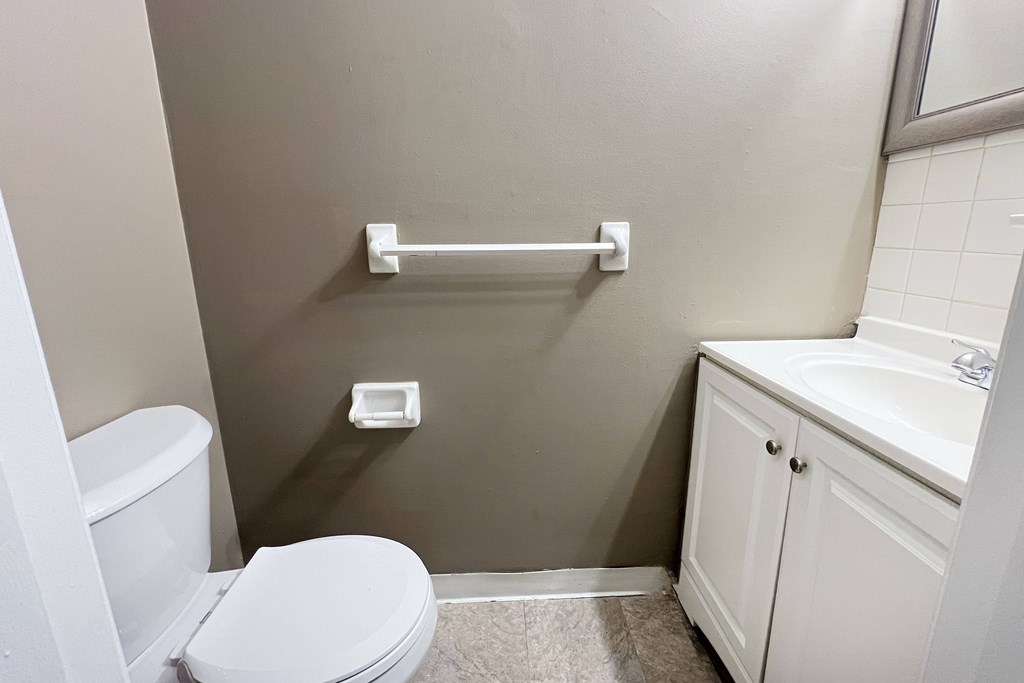 A white toilet sits next to a white sink in a small bathroom.
