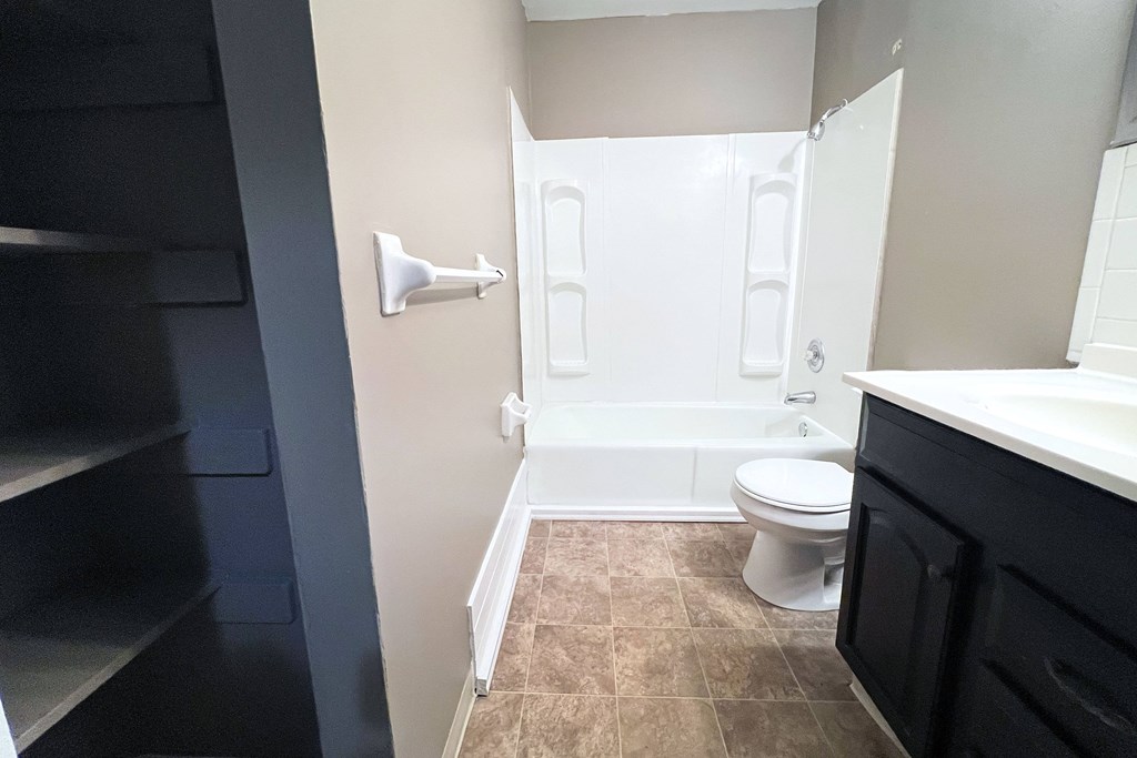 A bathroom with a toilet, sink, and a shower stall.