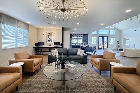 A living room with a glass table and leather chairs.