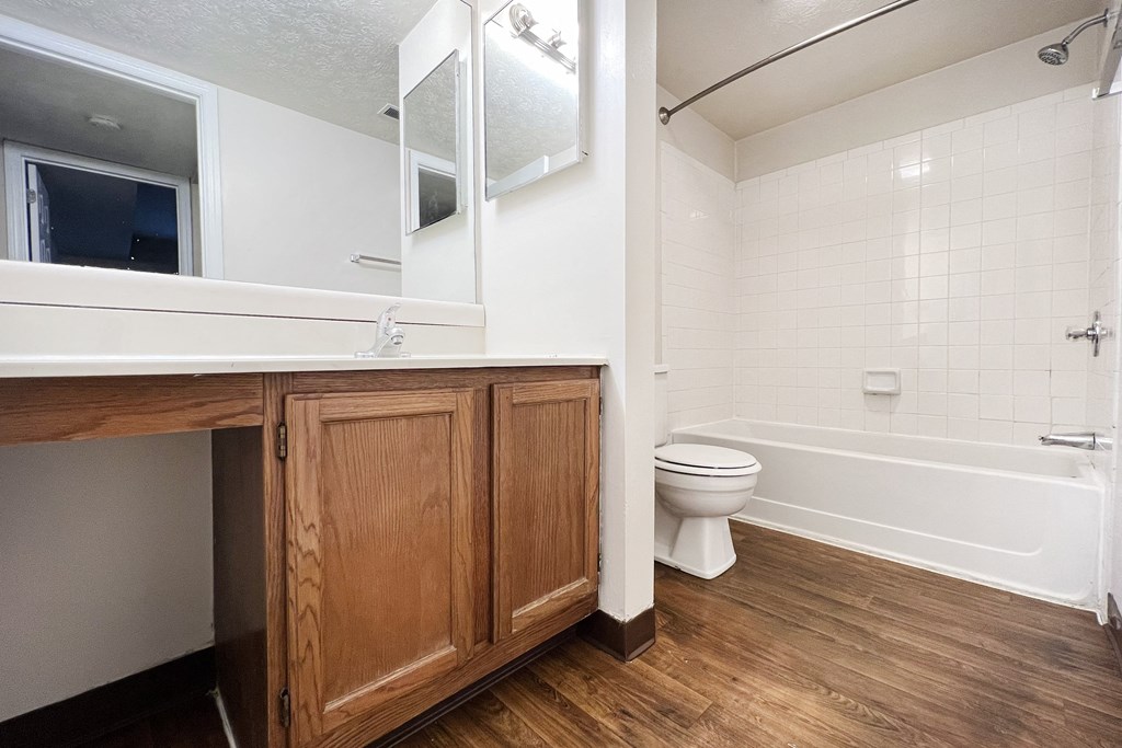 a bathroom with a toilet and a sink and a mirror at Deercross in Blue Ash, OH