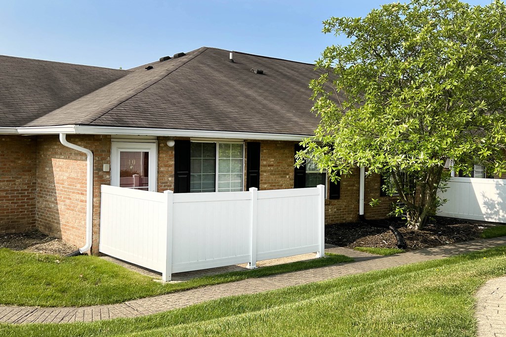 a house with a white fence in front of it  at Wyndemere Apartments, Franklin, OH