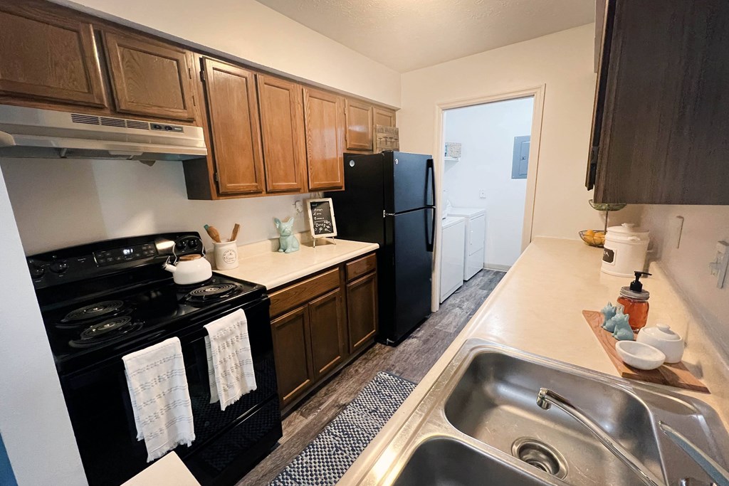 a kitchen with a black refrigerator freezer next to a stove top oven  at Steeplechase Apartments, Ohio, 45140