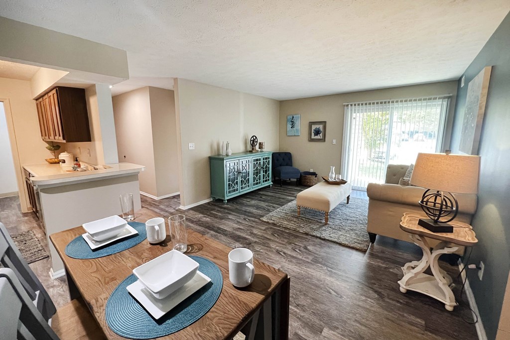 a living room with a dining table and a kitchen in the background  at Steeplechase Apartments, Ohio