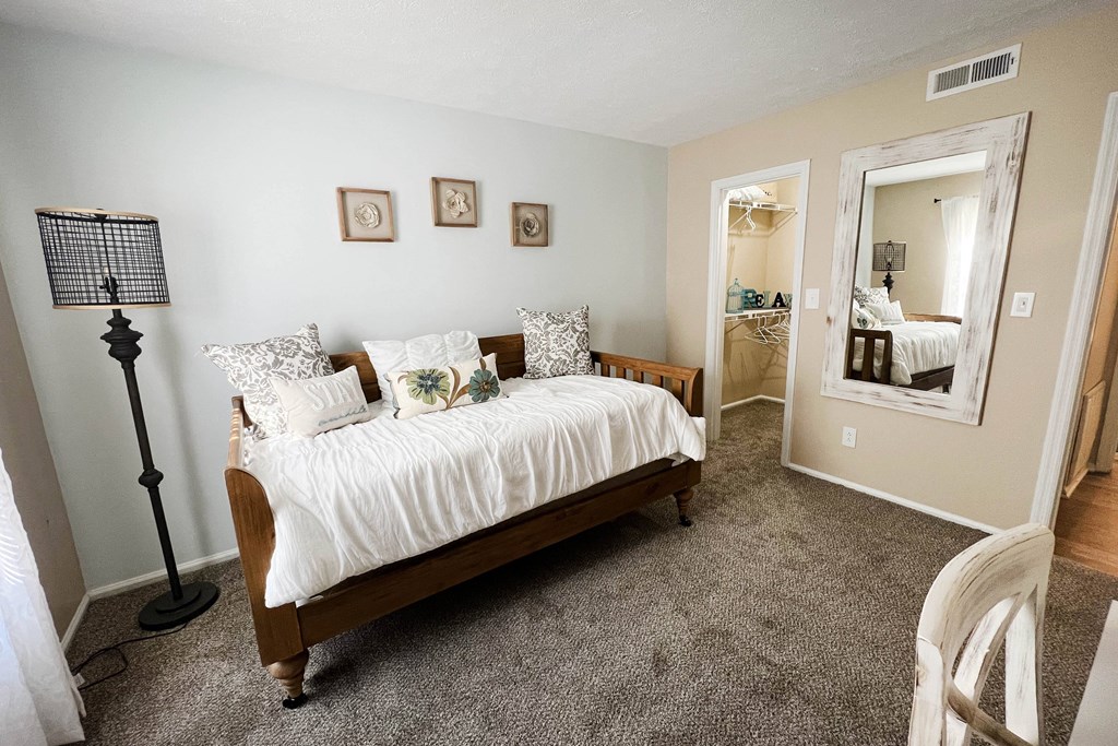 a bedroom with a bed and a lamp  at Steeplechase Apartments, Loveland