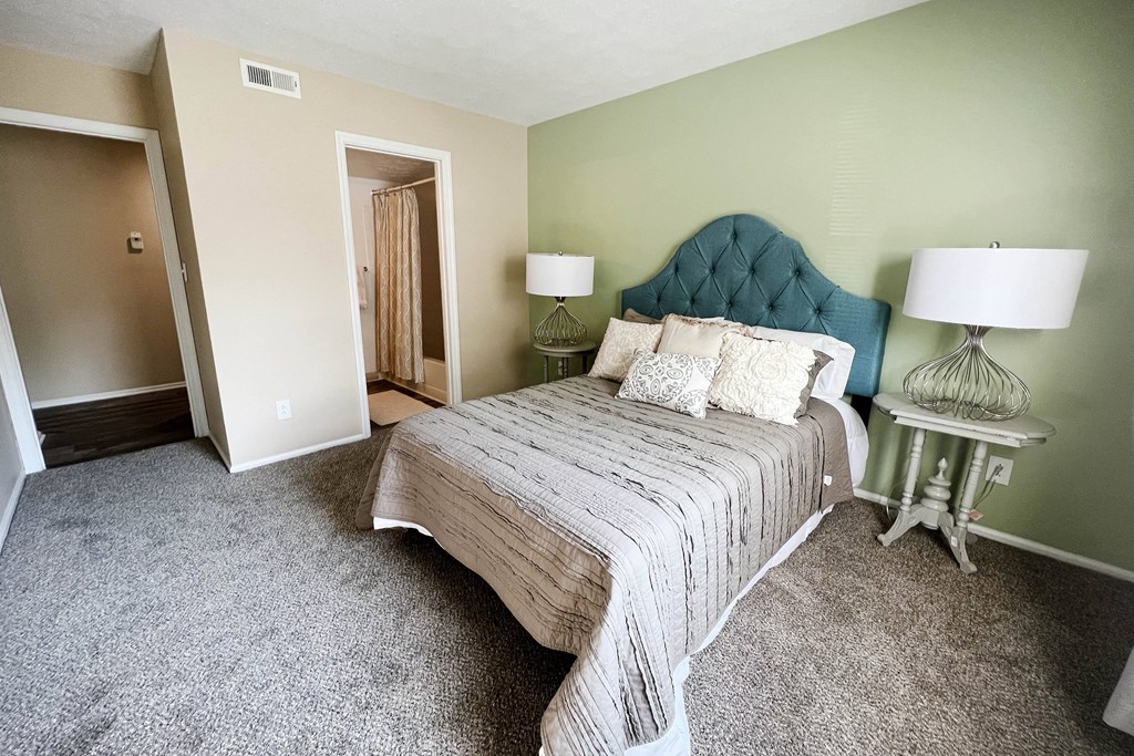 a bedroom with a bed and two lamps  at Steeplechase Apartments, Loveland, 45140
