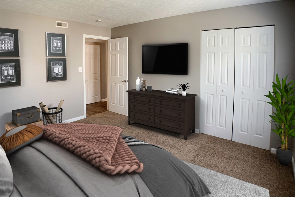 a bedroom with a bed and a dresser with a television  at Knobs Pointe Apartments, New Albany, Indiana