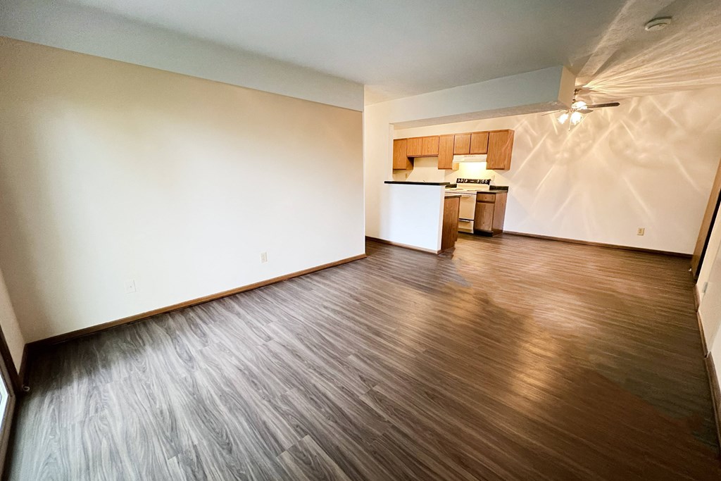 an empty living room with wood floors and a kitchen at Forest Creek Apartments, Middletown, Ohio