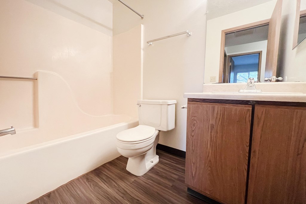 a bathroom with a toilet and a sink and a mirror at Forest Creek Apartments, Middletown