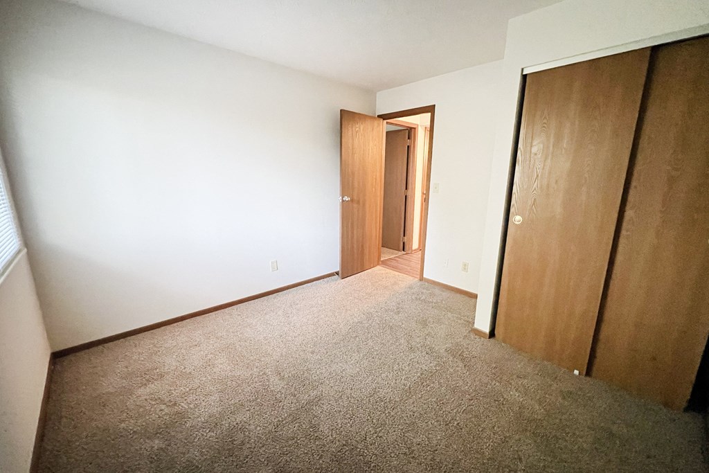 a bedroom with a carpeted floor and a door to a closet at Forest Creek Apartments, Middletown, 45044
