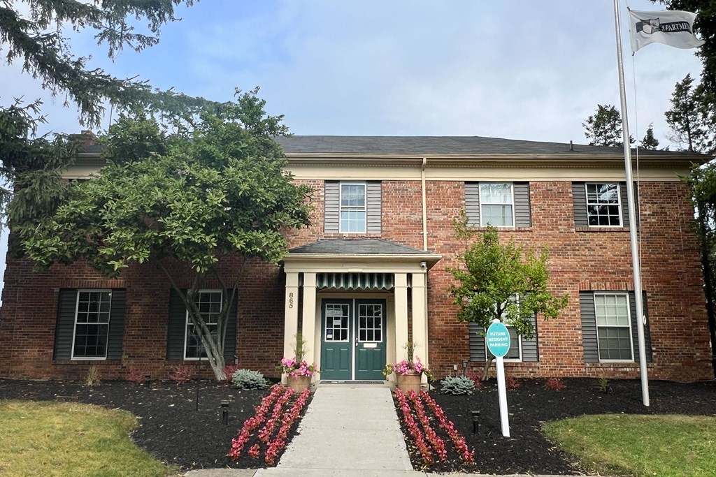a brick building with a green door and a street sign