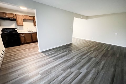 an empty living room with wood floors and a kitchen at Crown Court Apartments, Florence, 41042