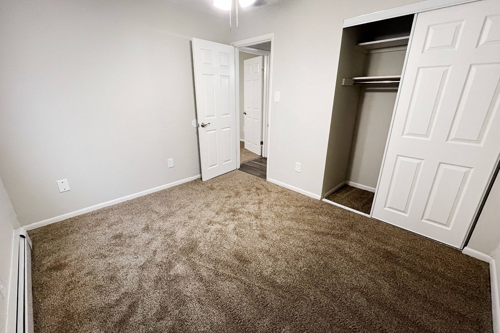 an empty bedroom with a carpeted floor and a closet at Crown Court Apartments, Florence