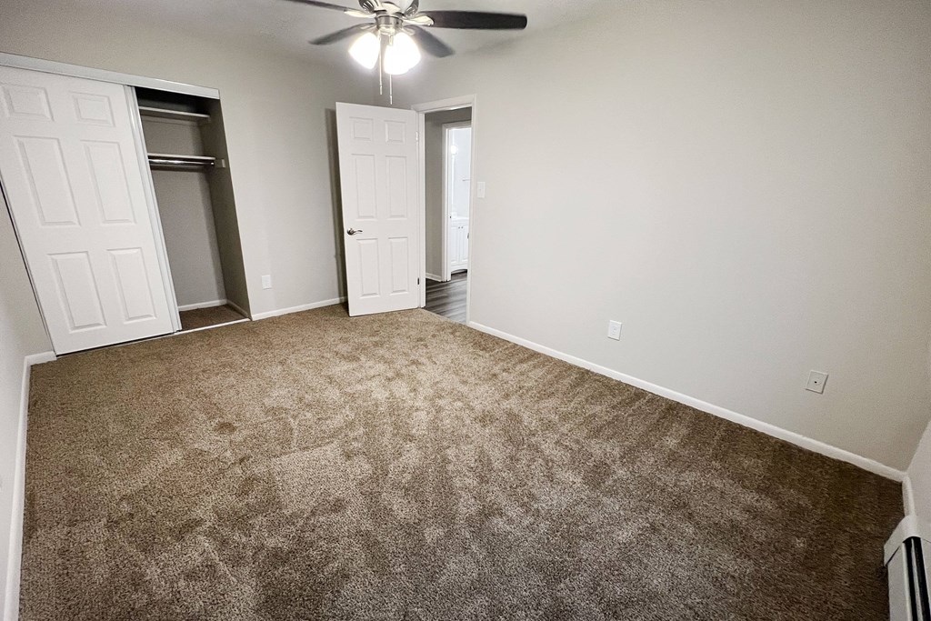 an empty living room with carpet and a ceiling fan at Crown Court Apartments, Kentucky, 41042