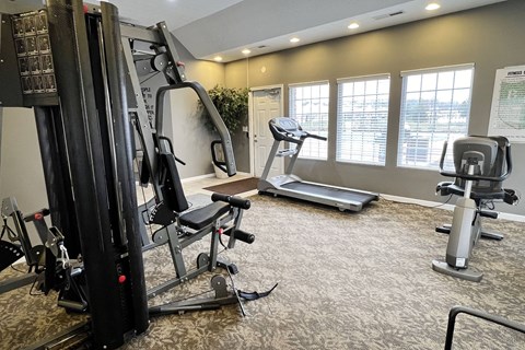 a gym with exercise equipment on the floor and windows