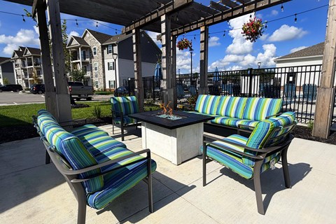 Two striped chairs and a table are on a patio.