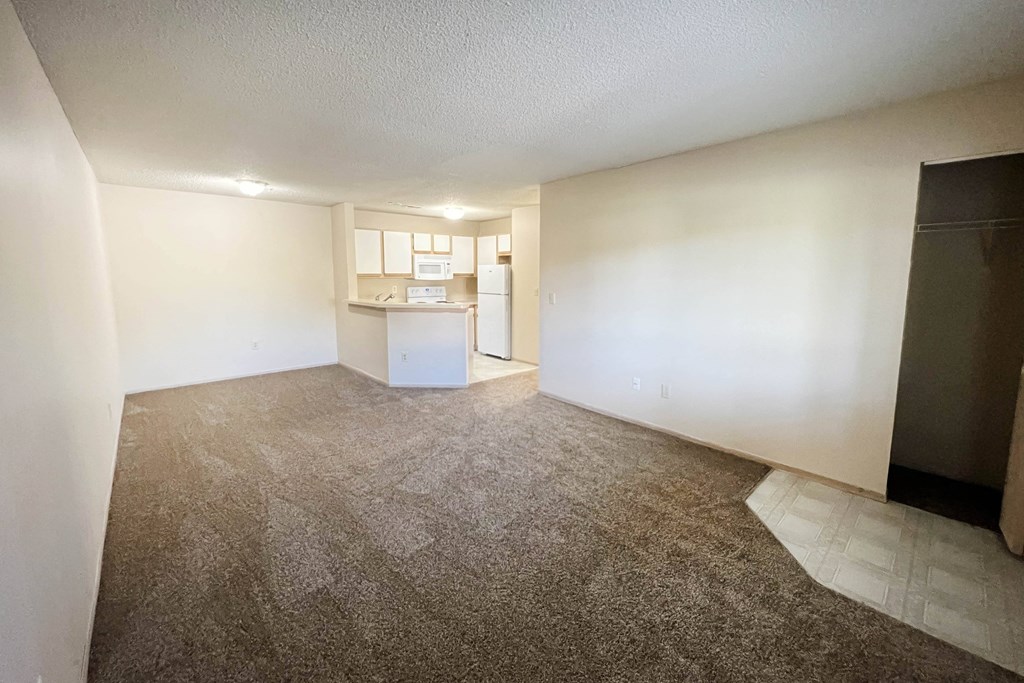 the living room and kitchen of an empty apartment with carpeting at Eagle Crest Apartments, Galloway, 43119