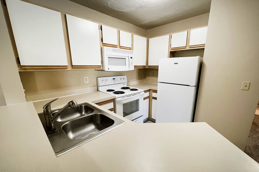 an empty kitchen with white cabinets and appliances and a sink at Eagle Crest Apartments, Galloway