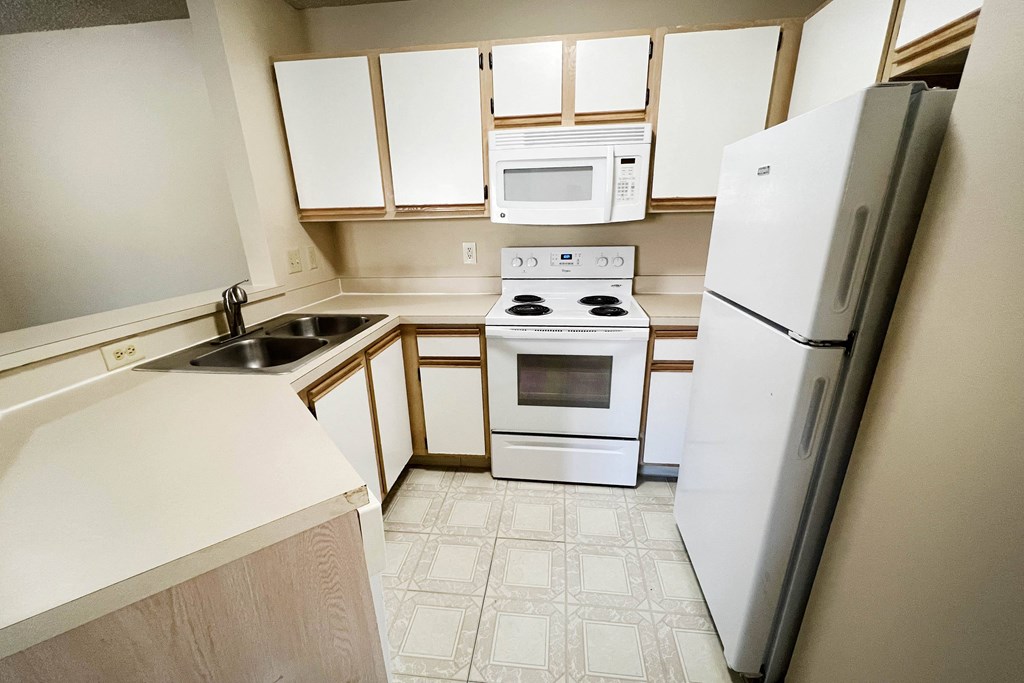 an empty kitchen with white appliances and white cabinets at Eagle Crest Apartments, Galloway, OH