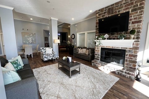 a living room with a brick fireplace and a tv