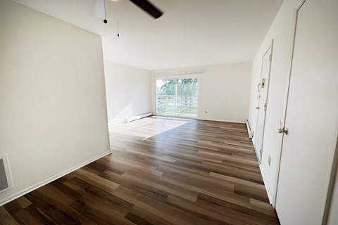 a living room with a hard wood floor and white walls