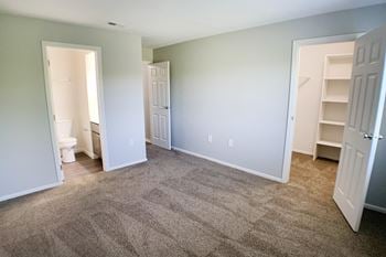 an empty living room with carpeting and a closet and a toilet at Deercross Apartments, Ohio