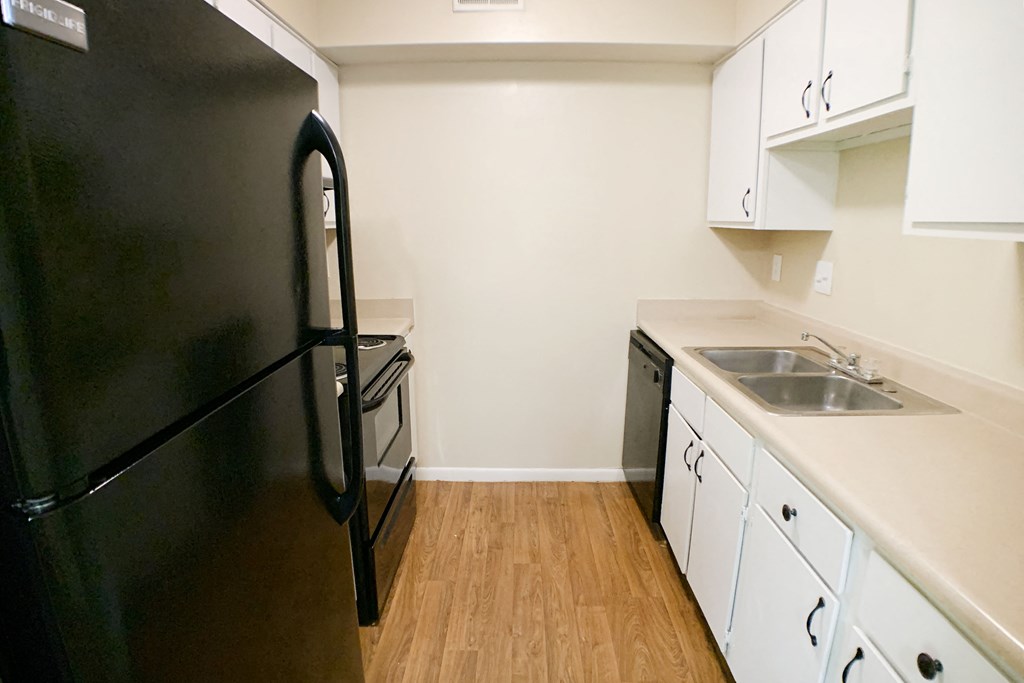 a kitchen with white cabinets and a black refrigerator  at Hunter's Creek Apartments, Cincinnati, OH, 45242