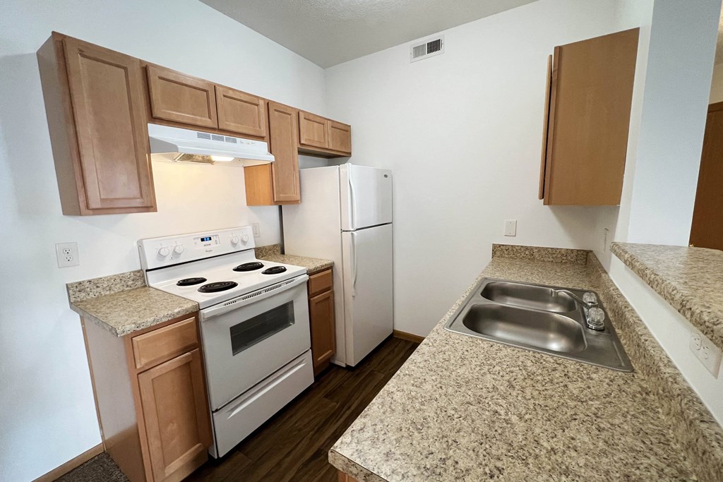 a kitchen with white appliances and granite counter tops  at Brookfield Village Apartments, Grove City