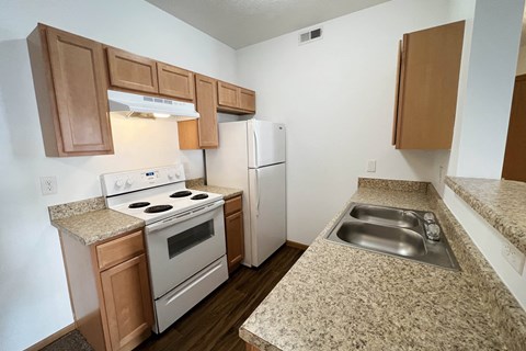 a kitchen with white appliances and granite counter tops  at Brookfield Village Apartments, Grove City