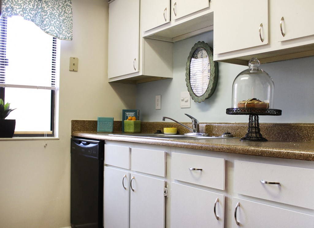 a kitchen with white cabinets and a sink and a window  at Hunter's Creek Apartments, Cincinnati, OH