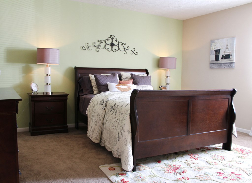 a bedroom with a bed and two lamps  at Hunter's Creek Apartments, Ohio, 45242
