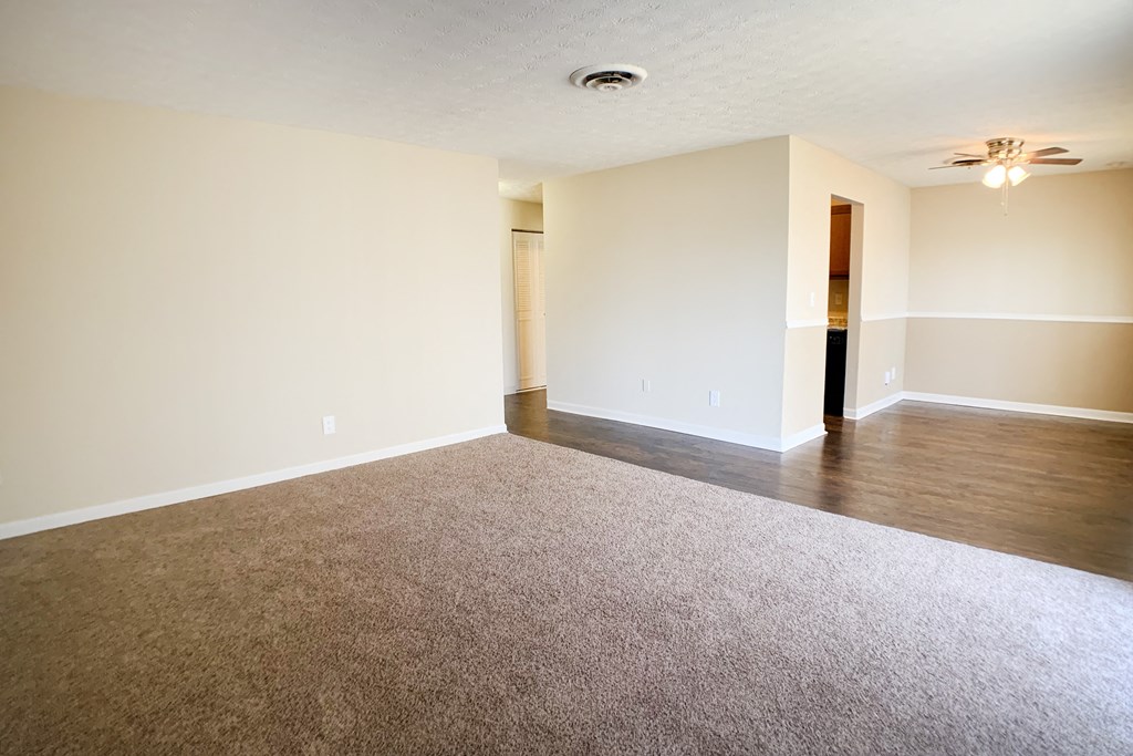 an empty living room with carpet and a ceiling fan  at Timber Ridge Apartments, Cincinnati