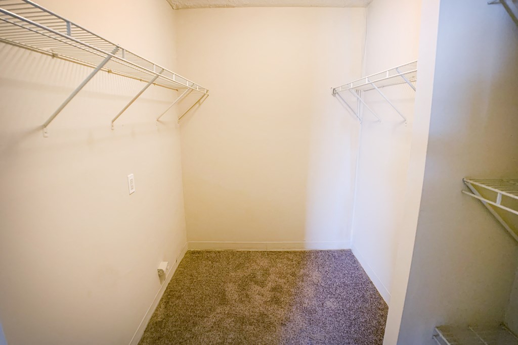 a walk in closet with a carpeted floor and two hanging racks  at Timber Ridge Apartments, Cincinnati