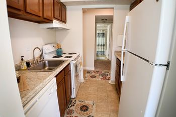 A kitchen with a white fridge and a white stove.
