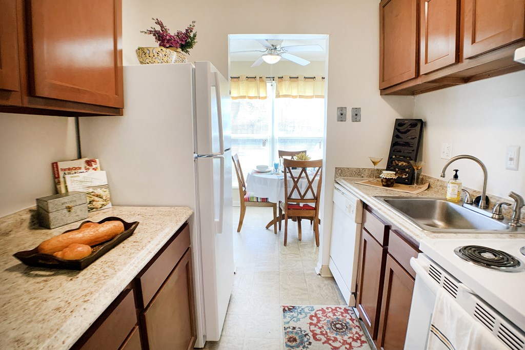 a kitchen with wooden cabinets and a sink and a refrigerator at Timber Ridge Apartments, Cincinnati