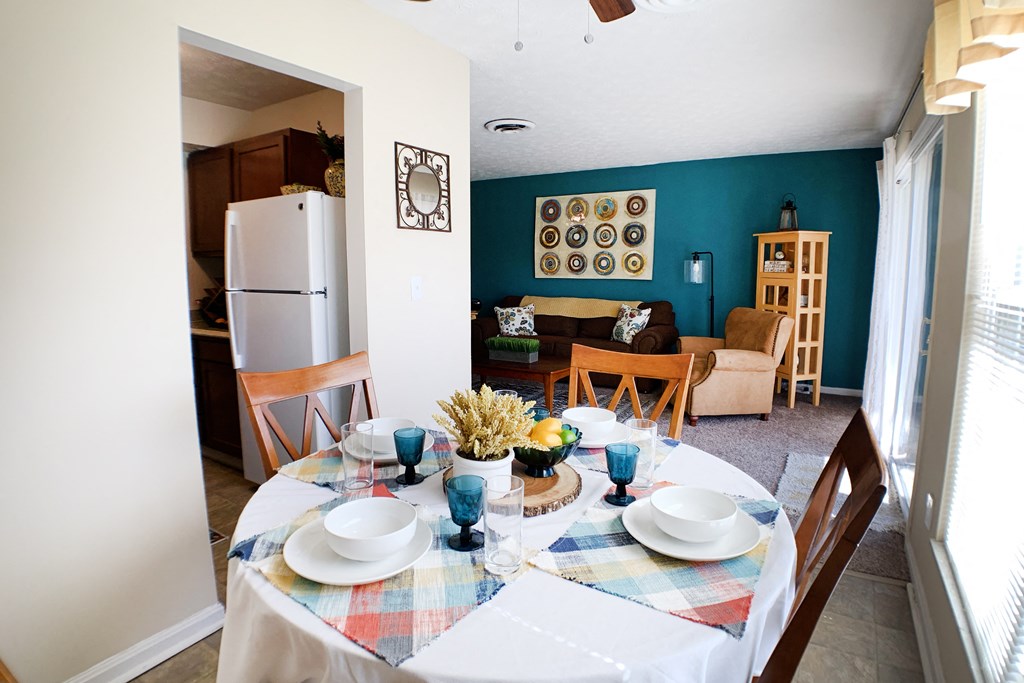 a dining room and living room with a table and a refrigerator  at Timber Ridge Apartments, Cincinnati, Ohio