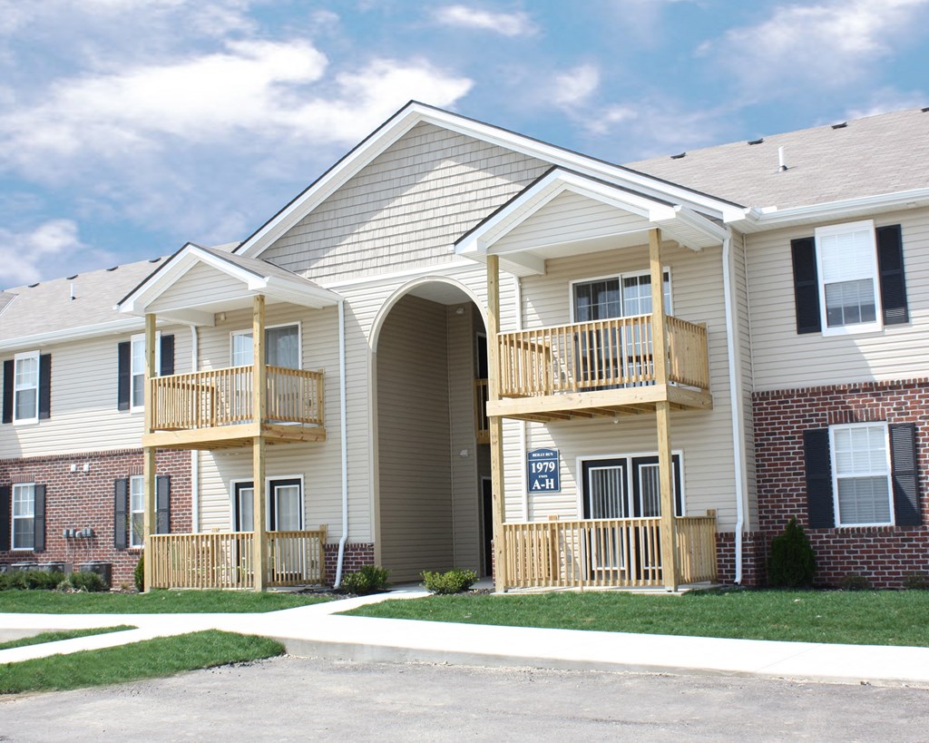 the exterior of a building with two balconies and a sign on the door