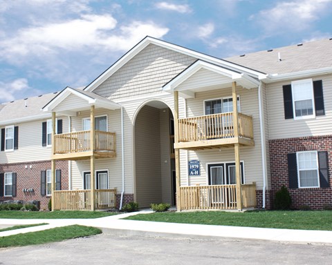 the exterior of a building with two balconies and a sign on the door