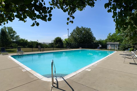 a swimming pool with chairs and a fence around it  at Knobs Pointe Apartments, New Albany