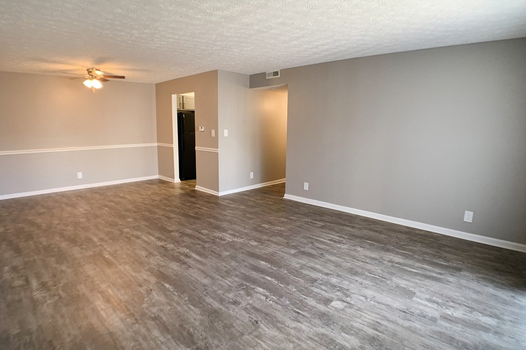 an empty living room with wood floors and a ceiling fan  at Knobs Pointe Apartments, Indiana