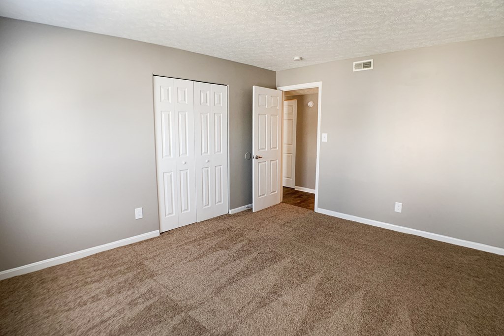 an empty living room with carpet and two doors  at Knobs Pointe Apartments, New Albany, IN, 47150